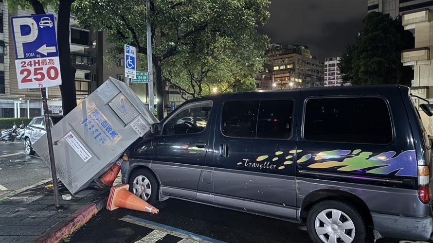 舊衣回收箱遭強風吹倒,重擊停放轎車,造成嚴重損壞。(圖/今大條新聞網拍攝)